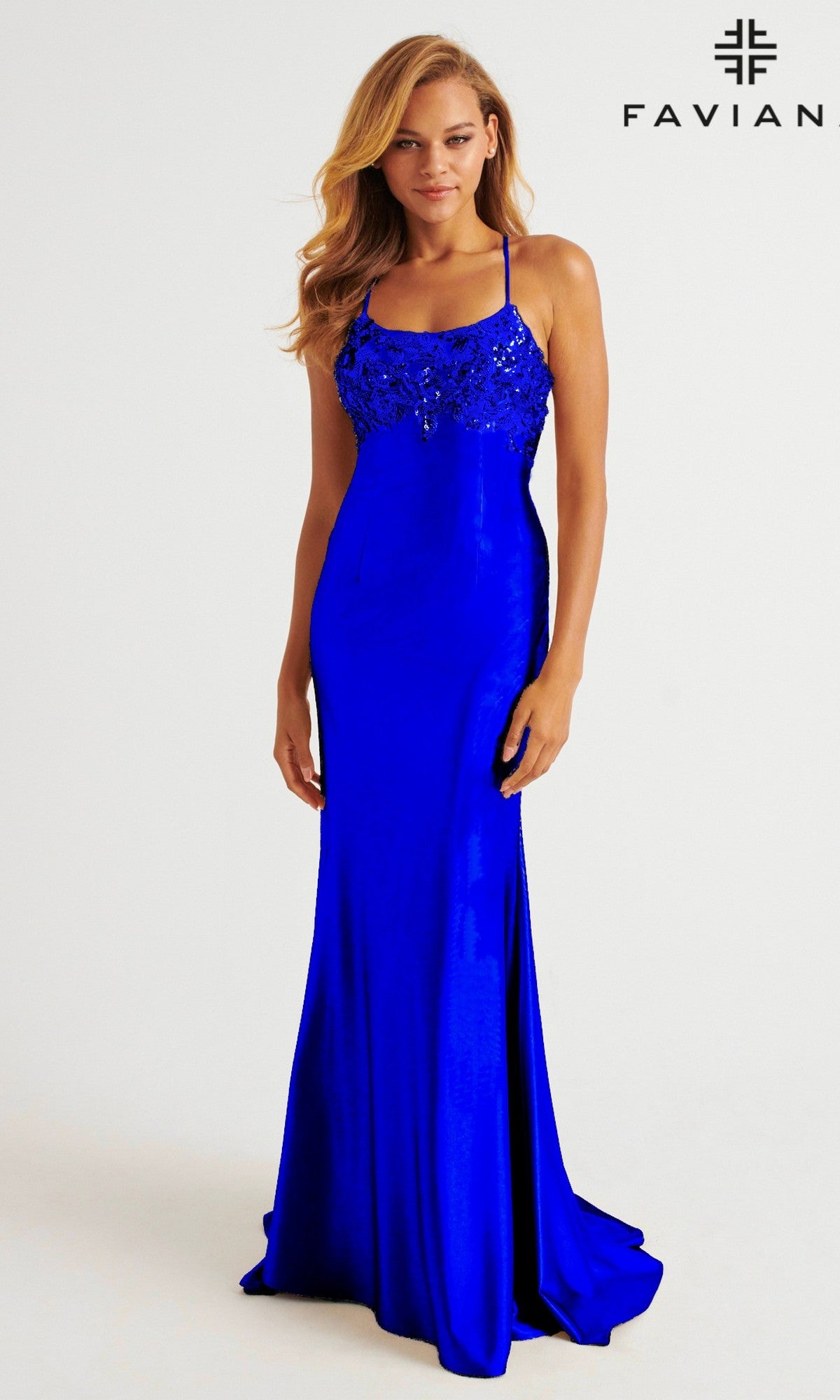 A woman in a Faviana E11201 strappy open-back long prom dress with a beaded bodice stands against a plain background, the